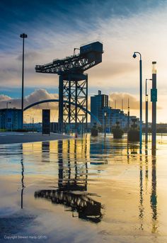 a large crane sitting on top of a body of water next to a tall building