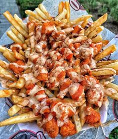 chicken and french fries covered in sauce on a plate