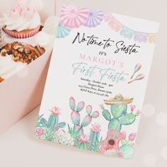 a box filled with lots of cupcakes next to a sign that says it's margots first fiesta