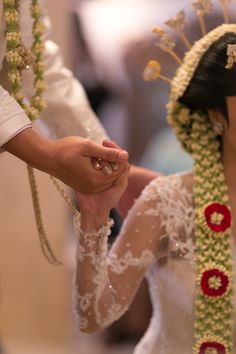 the bride and groom hold hands as they walk down the aisle