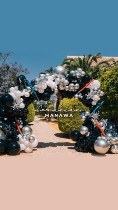 mickey mouse balloon arch at the entrance to an area that is decorated with silver and black balloons