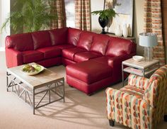 a living room with red leather couches and chairs