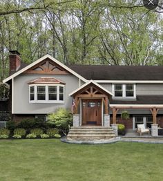 a large gray house in the middle of some trees