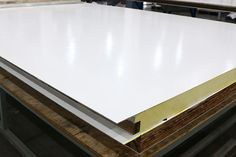 several pieces of white plywood are stacked on top of each other in a warehouse