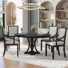 a round dining table with four chairs and a vase on the top, in front of a bookcase