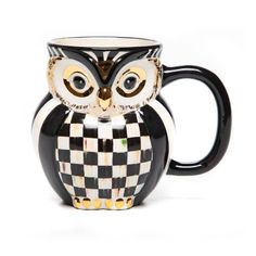 a black and white owl mug with gold accents on it's face, sitting in front of a white background