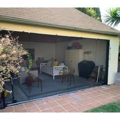 a patio with a table and chairs in the middle of it next to a house