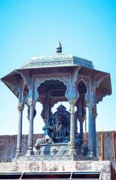 a statue on top of a building with a blue sky in the backround