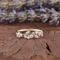 a close up of a ring on a piece of wood with flowers in the background