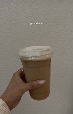 a woman holding a cup of coffee in her right hand with the caption happiness is a cup