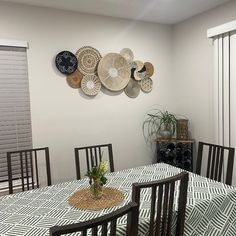 a dining room table and chairs with plates on the wall