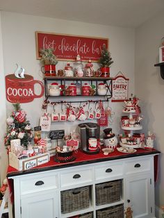 a christmas display with red and white items on it's shelf, including coffee mugs