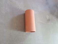 a roll of clay sitting on top of a cement floor next to a white wall