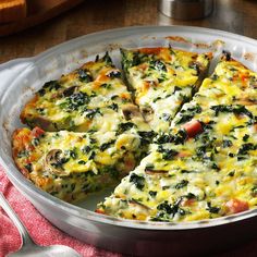 a casserole with spinach, cheese and mushrooms in a pan on a table