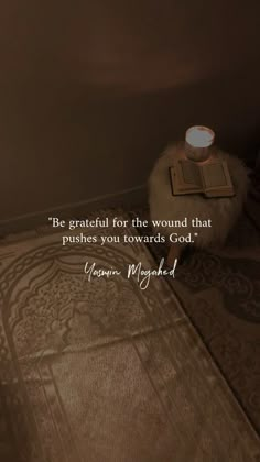 a candle sitting on top of a rug next to a wall with a quote written in it