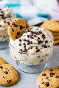 cookies and ice cream in a glass bowl with chocolate chips on the rim next to them