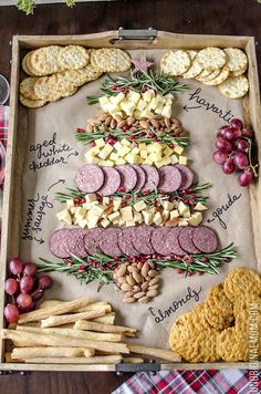 an assortment of cheeses, crackers, and meats on a serving tray