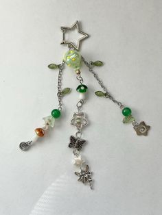 a necklace with charms and beads hanging from it's side on a white surface