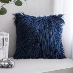 a blue pillow sitting on top of a white shelf next to a box of tissues