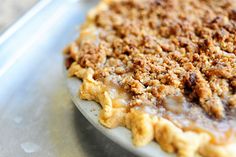 a pie with crumbs on it sitting on top of a metal pan next to a fork