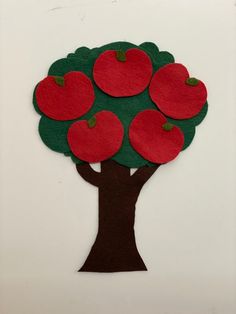 an apple tree made out of felt with red apples on it