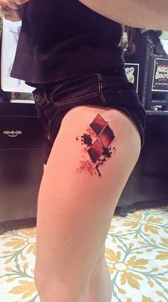 a woman's leg with a tattoo on it that has red and black designs