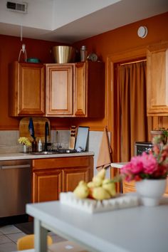 a kitchen with orange walls and wooden cabinets