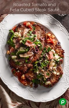 a white plate topped with meat covered in toppings