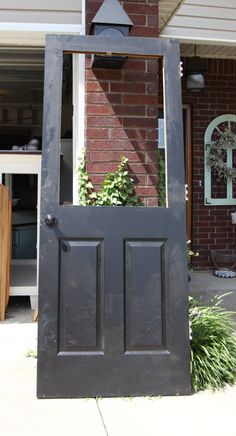 an open door on the side of a brick building with plants growing out of it