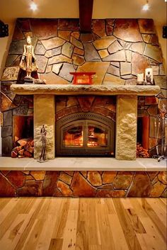 a stone fireplace with wood flooring in a living room