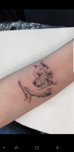 a small dog tattoo on the left arm and right arm, with an ink pen in it