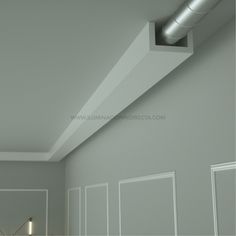 an empty room with white walls and a metal pipe on the ceiling in front of it