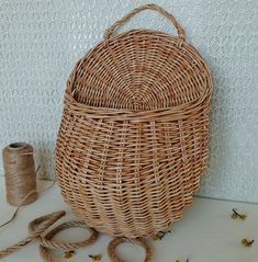 a wicker basket sitting on top of a table next to a spool of twine