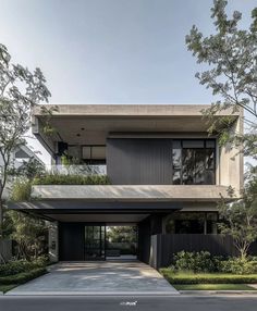 a modern house with black and white architecture on the outside, surrounded by greenery