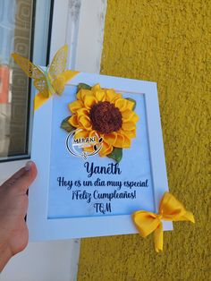 a person holding up a card with a sunflower on it and a yellow butterfly