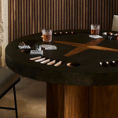 a black table topped with lots of different types of knives and glasses on top of it