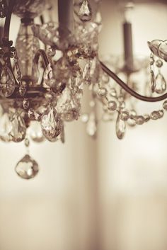 a chandelier hanging from the ceiling with lots of crystal beads on it's arms