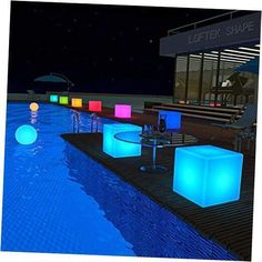 an outdoor pool with illuminated cube tables and chairs