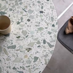 a cup sitting on top of a table next to a pair of shoes