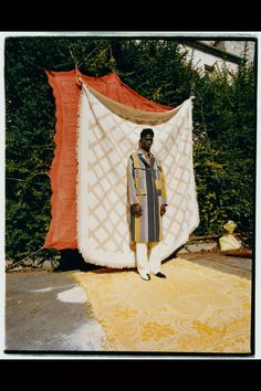 a man standing in front of a white and orange tent