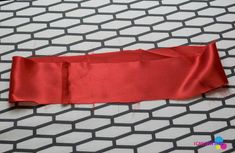 a piece of red fabric is laying on the floor with it's end cut off