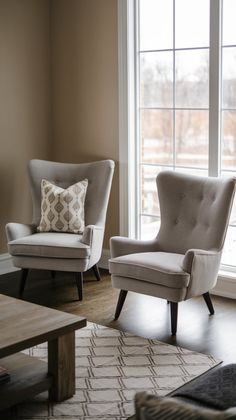 two chairs and a coffee table in front of a large window with windows on both sides