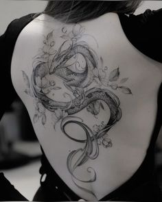 the back of a woman's body with tattoos on it