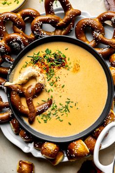 a bowl of soup with pretzels on the side