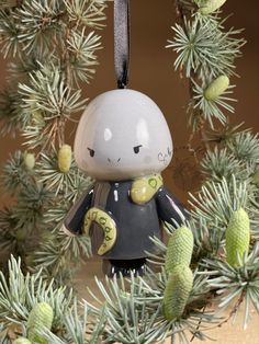 a christmas ornament hanging from a pine tree