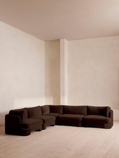 a living room with a large sectional couch in the middle and a painting on the wall