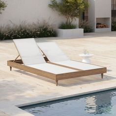 an empty lounge chair sitting next to a pool in the middle of a patio area