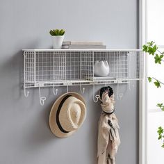 a hat and scarf hanging on a wall next to a coat rack with two hats