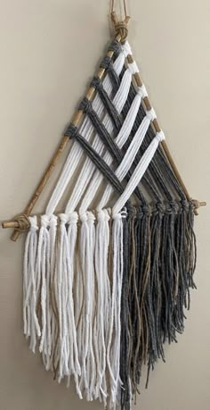 a wall hanging made out of yarn and wood sticks