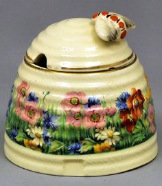 a ceramic covered jar with flowers painted on it